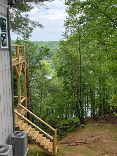 a deck on the side of a house with trees at The Overlook at Lake James in Nebo