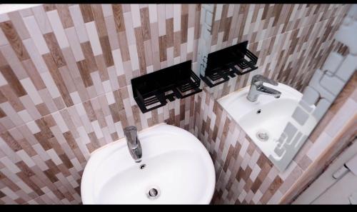 a bathroom with a white sink and a mirror at Holly Precious Home in Dar es Salaam