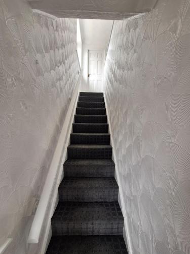 a staircase in a building with white walls at Florina house in Little Hulton