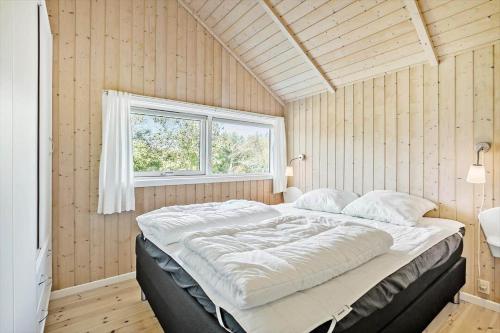 a large bed in a room with a window at JB223-Brovst-Kronvildtvej-18 in Tranum