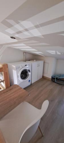 a room with a washing machine and a table at Maison de bourg in Jumeaux