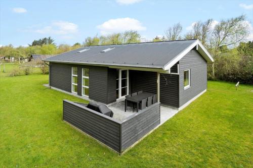 una pequeña casa con terraza en un patio en JB165-Fjerritslev-Ostersvej-16, en Slettestrand