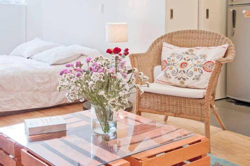 ein Wohnzimmer mit einem Tisch und einer Blumenvase in der Unterkunft L'Olive in Mexiko-Stadt