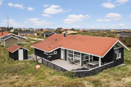 a house with an orange roof on top of a field at JB705-Frostrup-Svenstibakkevej-82 in Lild Strand