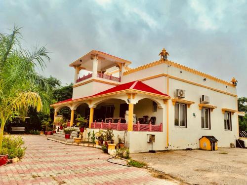 a house with a balcony on top of it at Gift city farmhouse in Gandhinagar
