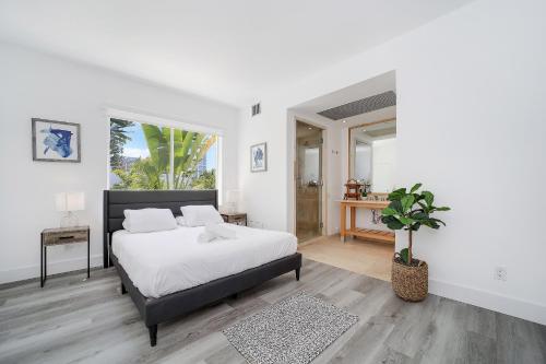 Dormitorio blanco con cama y maceta en St Augustine Hotel, en Miami Beach