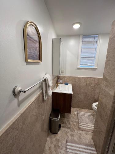 a bathroom with a sink and a toilet and a mirror at The Orange House in Washington, D.C.