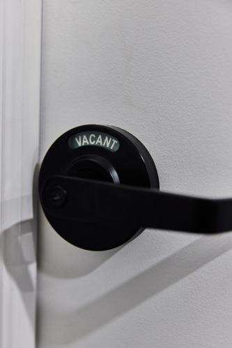 a black door handle on a white door at Capsule Hotel Montreal in Montréal