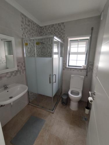 a bathroom with a shower and a toilet and a sink at Brisa do Mar 2 - Consolação in Peniche