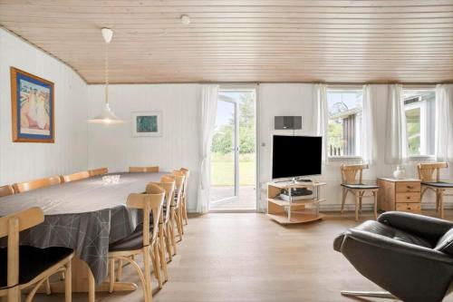 a living room with a dining table and a television at JB205-Fjerritslev-Tyttebaerstien-12 in Torup Strand