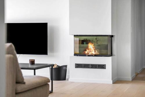a living room with a fireplace and a tv at JB190-Fjerritslev-Stenhusvej-34-B in Slettestrand