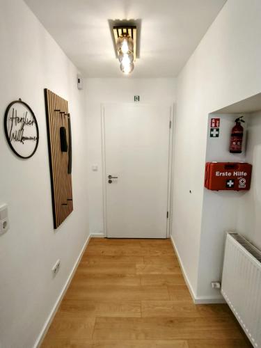 a hallway with a white door and a wooden floor at Danube Rooms - Self Checkin - Küche in Passau