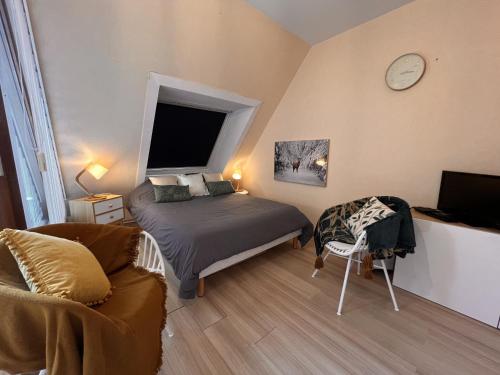 a bedroom with a bed and a couch and a clock at Studio Belle Vue in Aix-les-Bains