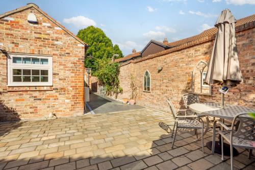 a patio with an umbrella and a table and chairs at Moatside Gate in York