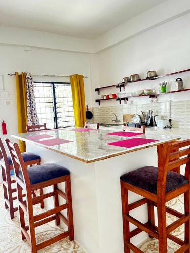 a kitchen with a counter with two chairs and a island at jahazi homes -watamu in Watamu