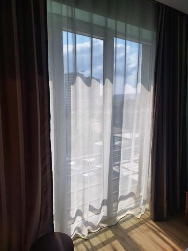 a window with white curtains in a room at Hotel Nina in Tbilisi City