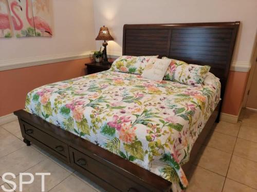 a bedroom with a bed with a floral bedspread at Island Time #4 condo in South Padre Island