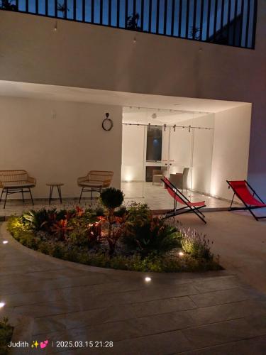 a courtyard with benches and a flower bed with lights at Love us in Tequisquiapan