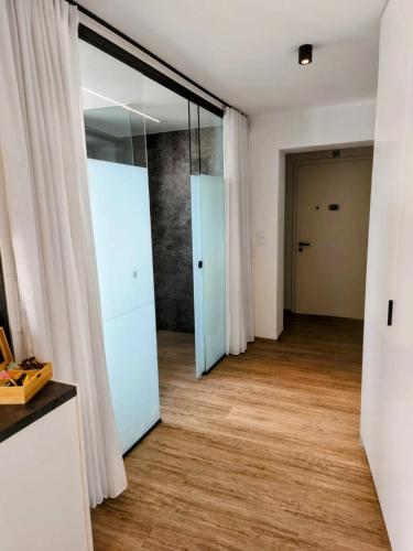 a hallway with sliding glass doors and wood floors at Danube Rooms - Self Checkin - Küche in Passau