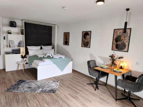 a bedroom with a bed and a desk and a table at Danube Rooms - Self Checkin - Küche in Passau