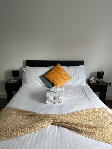 a bed with two towels and pillows on it at Canary Wharf - Luxury Apartments in London
