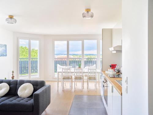 a living room with a couch and a table at Parisian Haven - Chic Penthouse near Paris & CDG in Le Blanc-Mesnil
