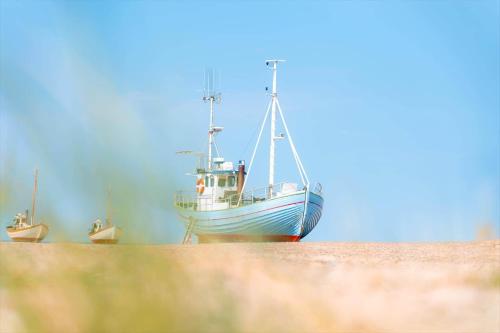 a boat sitting in the sand on the beach at JB391-Fjerritslev-Perikumvej-62 in Slettestrand