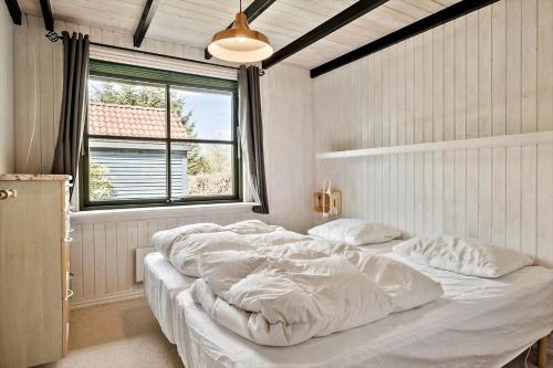 a bedroom with a large white bed with a window at JB314-Fjerritslev-Tyttebaerstien-13 in Torup Strand