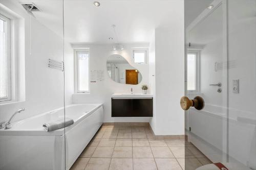 a white bathroom with a tub and a sink at JB221-Brovst-Kronvildtvej-182 in Tranum