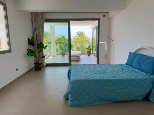 a bedroom with a bed with a blue comforter at Penthouse Panoramic Ocean Views - By Bobbywashere in Santa Maria