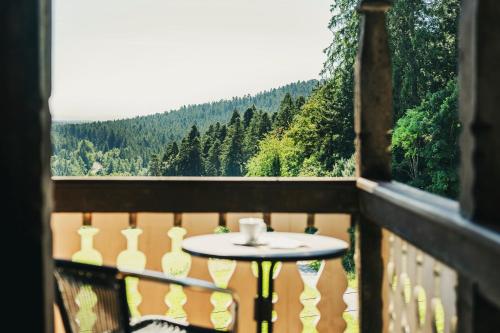 a table on a balcony with a view of trees at Fritz Lauterbad in Freudenstadt