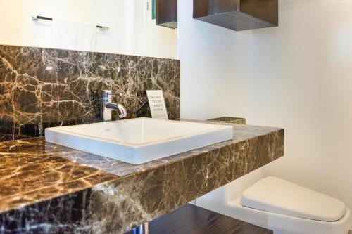 a bathroom with a sink and a toilet at Villa RosMar Luxury Beachfront House in Cozumel