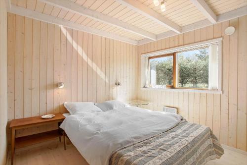 a bedroom with a bed with a table and a window at JB188-Fjerritslev-Kollerup-Klitvej-163 in Fjerritslev