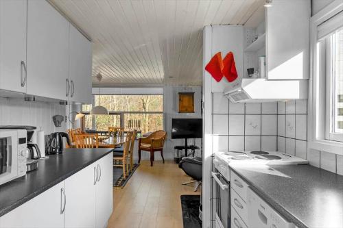 a kitchen with white cabinets and a dining room at JB179-Fjerritslev-Slojbrovej-77 in Gøttrup