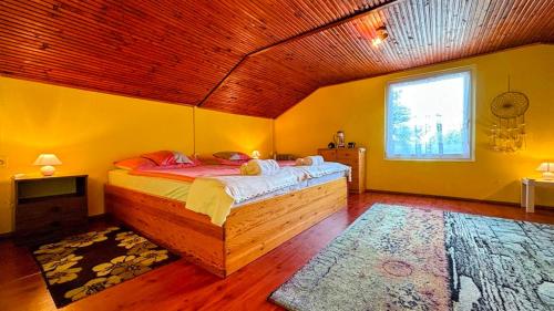 a bedroom with a bed in a room with yellow walls at Viktória Apartman DunaWeekend in Makád