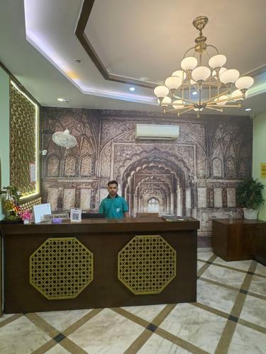 a man standing at a reception desk in a hotel lobby at Hotel Dev Sagar & Restaurant in Agra