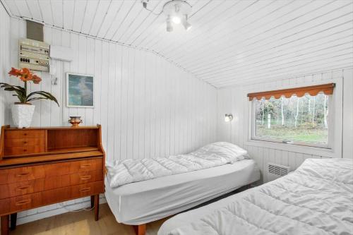 a bedroom with two beds and a dresser and a window at JB179-Fjerritslev-Slojbrovej-77 in Gøttrup