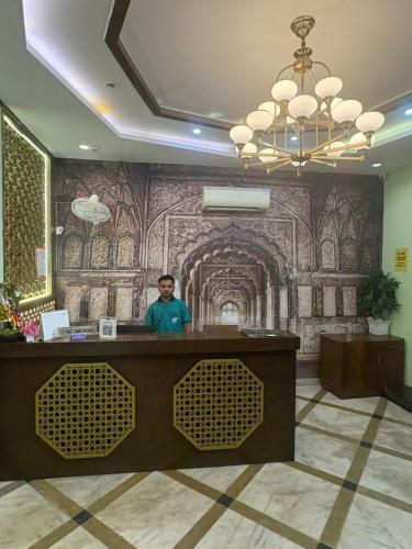 a man standing at a counter in a hotel lobby at Hotel Dev Sagar & Restaurant in Agra