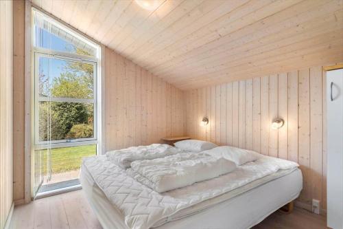 ein weißes Bett in einem Zimmer mit Fenster in der Unterkunft JB251 Fjerritslev - Egevej 5 in Fjerritslev