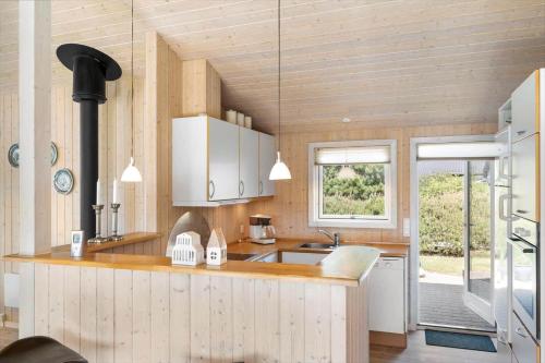 eine Küche mit weißen Schränken und einer Spüle und einem Fenster in der Unterkunft JB251 Fjerritslev - Egevej 5 in Fjerritslev