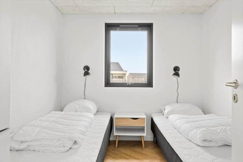 Dos camas en una habitación blanca con ventana. en JB172-Brovst-Kronvildtvej-110, en Tranum