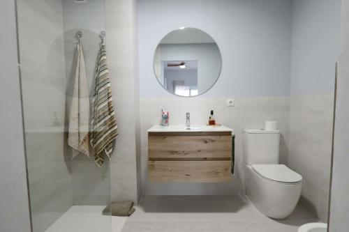 a bathroom with a toilet and a sink and a mirror at Castell Beach - Sea front - parking - swimming pool in Castell de Ferro