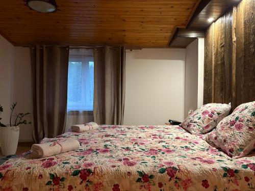 a bedroom with a large bed with flowers on it at Agroturystyka Na Wypasie in Grywałd