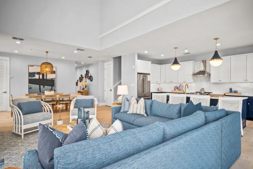 a living room with blue couches and a kitchen at Coastal Reverie TC 6301 in Mustang Beach