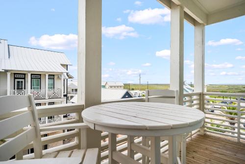 a white table and chairs on the porch of a house at Coastal Reverie TC 6301 in Mustang Beach