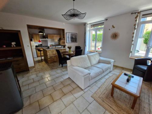 a living room with a white couch and a table at La maison de Victoire in Fourmies