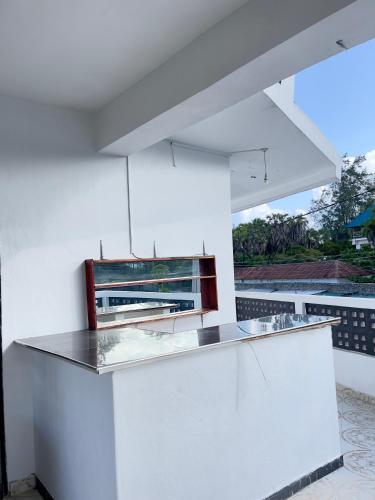 a white kitchen with a counter and a window at jahazi homes -watamu in Watamu