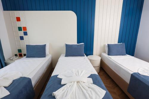 two beds in a room with blue and white walls at Forest In Hotel in Kemer