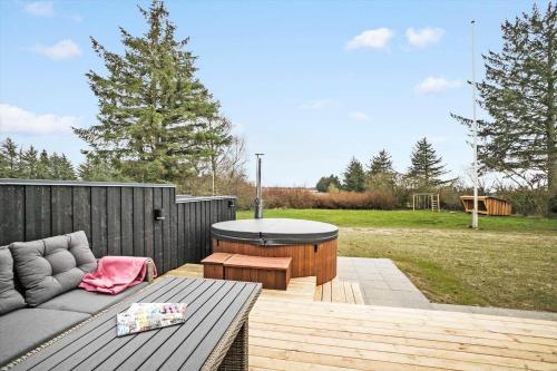 a patio with a couch and a table on a deck at JB200-Fjerritslev-Udklitvej-168 in Fjerritslev