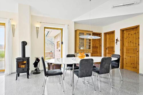 a dining room with a table and chairs and a stove at JB227-Frostrup-Andreas-Lassens-Vej-16 in Nørklit